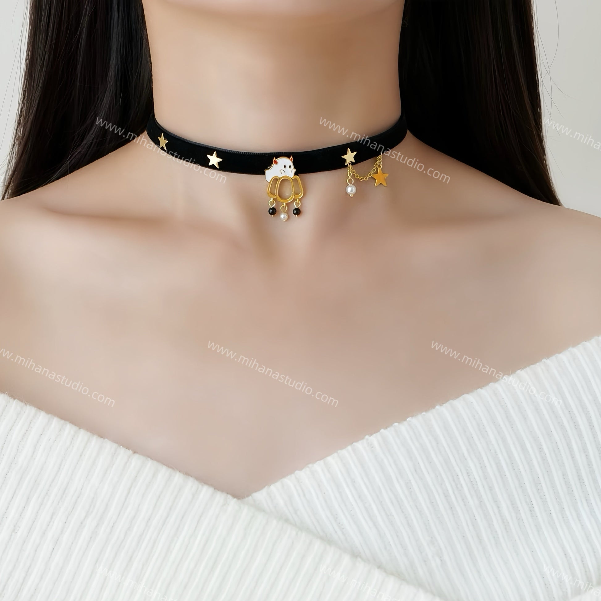 Black choker necklace with gold accents worn by a person against a white background
