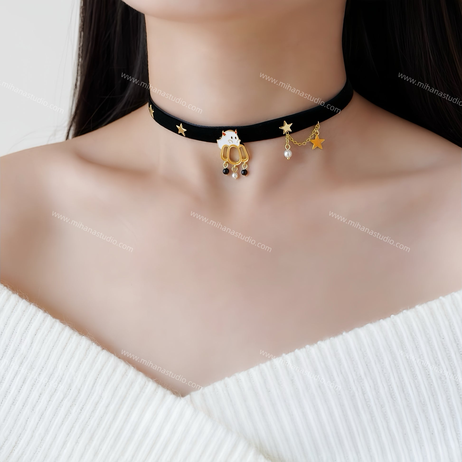Black choker necklace with cat and star charms worn by a person on a white background
