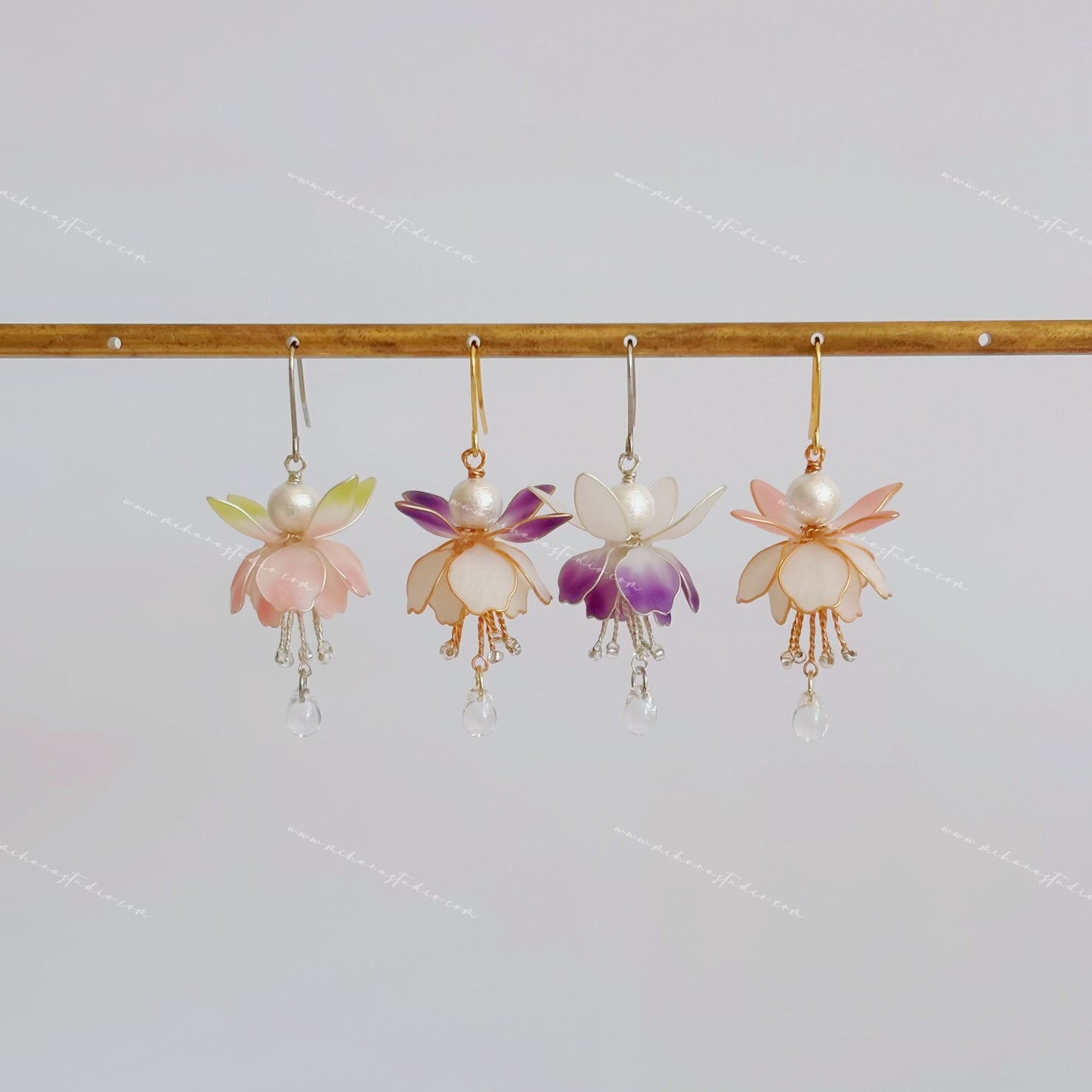 Fuchsia flower earrings hanging in four colourways