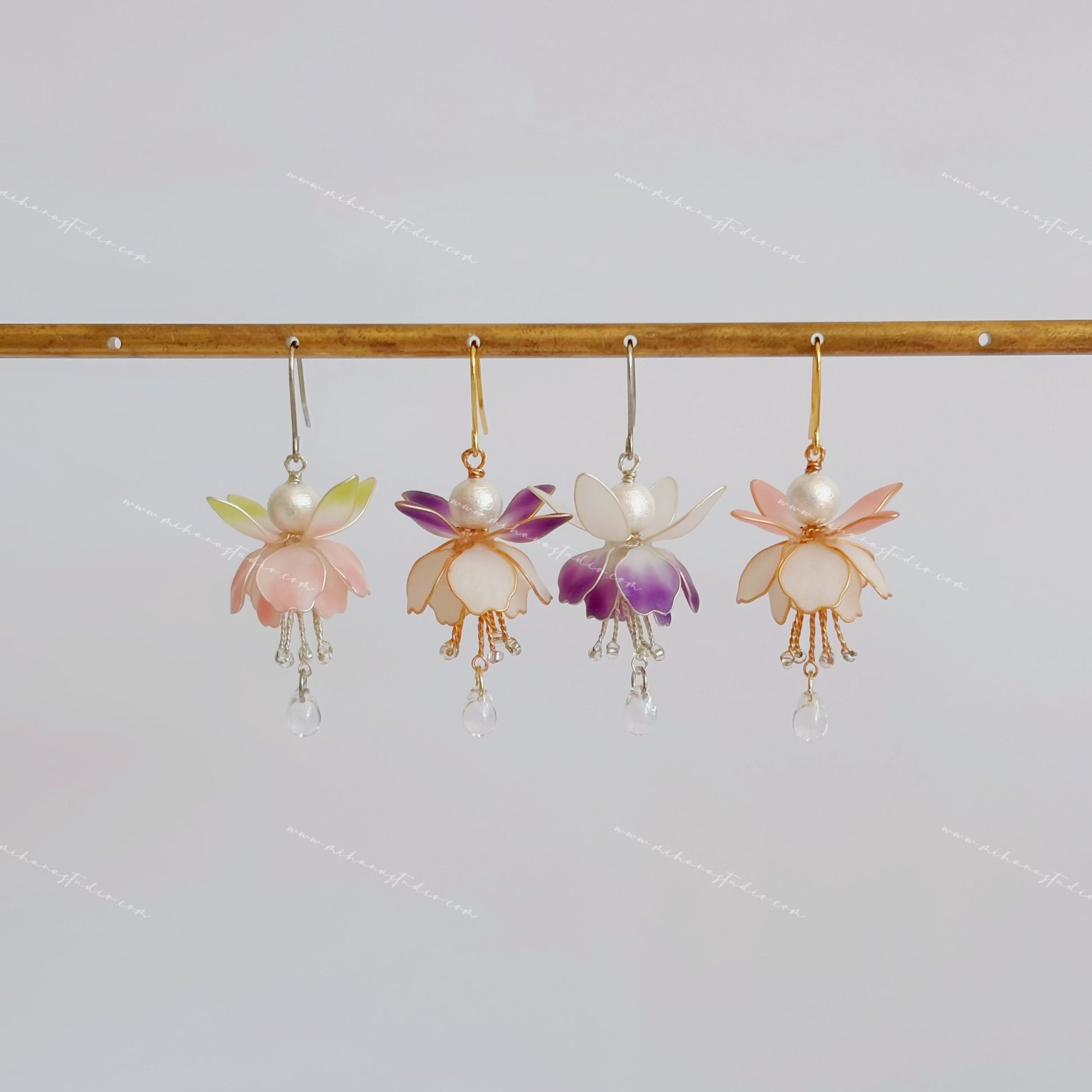 Fuchsia flower earrings hanging in four colourways